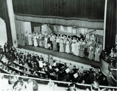 Cast members line up on stage for a final bow.