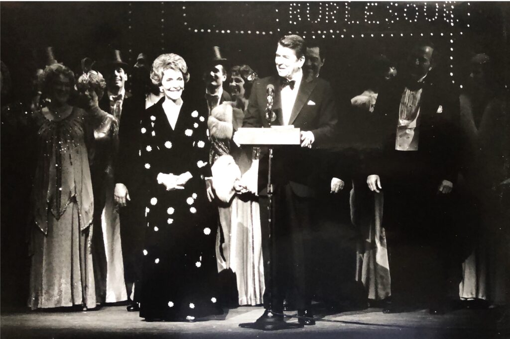 President and First Lady Reagan stand on stage speak from the stage of a performance.