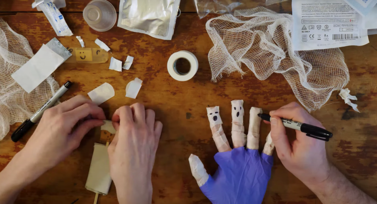 Two people make puppets with materials found at a hospital and their fingers.