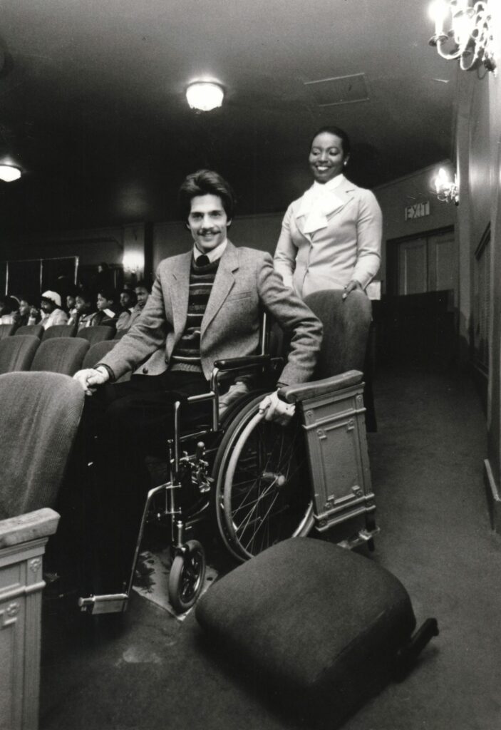 Man in wheelchair tests accessibility of theatre seat